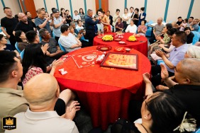 In a Taiyuan, Shanxi hotel, friends gather around round tables, slightly elevated in view, as they watch the bride eat dumplings, sharing warm smiles and enjoying the joyful wedding celebration together.